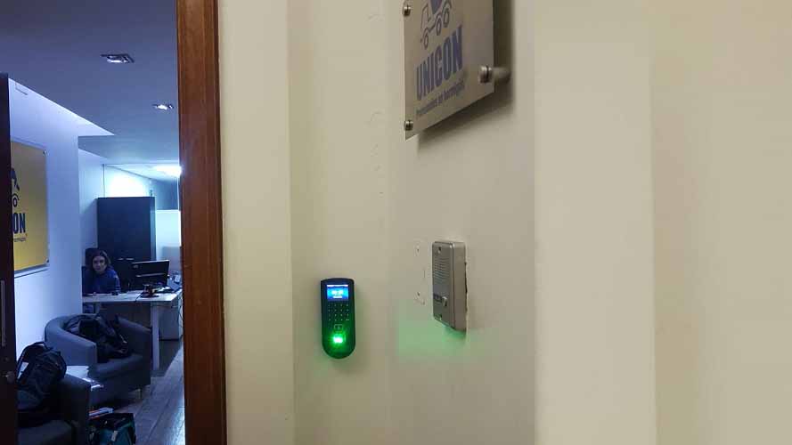Lector biométrico e intercomunicador instalados para controlar una puerta de oficina